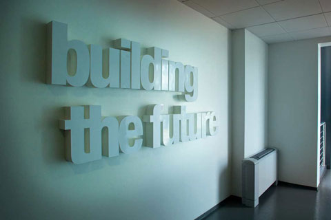 Scritta Building the Future installata sulla parete di un ingresso