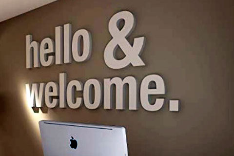 Scritta Hello e Welcome installata sulla parete di una reception